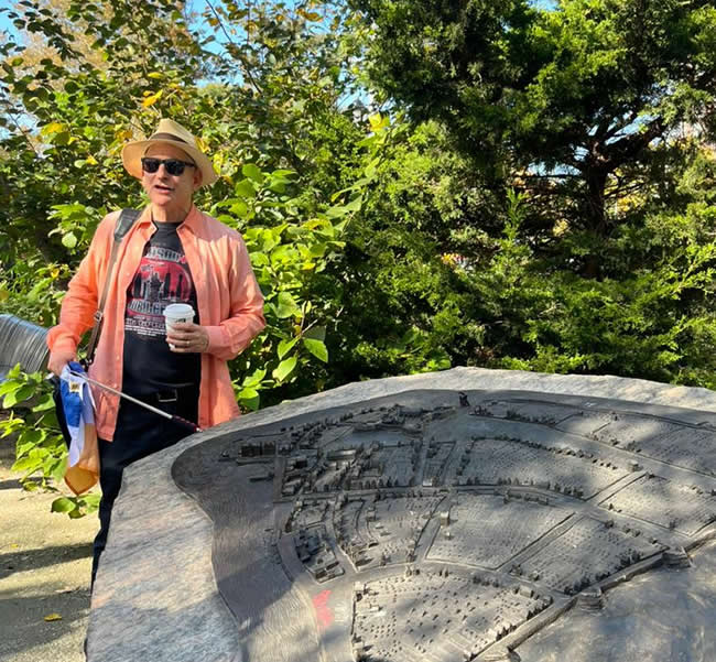 Jared standing at the bronze relief map of Central Park in the Conservatory Garden