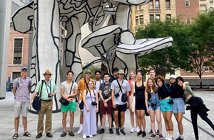 Jared's tour group posing in front of the black-and-white Jean Dubuffet sculpture 'Group of Four Trees' in Lower Manhattan
